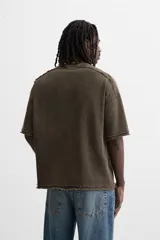 Camiseta gris de punto con efecto lavado, corte holgado, cuello redondo y mangas cortas.