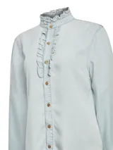 Camisa celeste de manga larga con cuello alto con volados y volados en el frente.