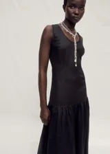 Vestido largo negro de lino y ramio, con cuello redondo, tirantes anchos y corte evasé.