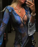 Vestido largo de microtul transparente, color azul oscuro con estampado floral en tonos azules y negros. Presenta escote pronunciado en V con volados en el borde y lazos ajustables en el centro, mangas largas con puños acampanados y volados, y abertura frontal.