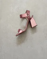 Sandalias plateadas con tira delantera, tobillera con hebilla y taco geométrico.