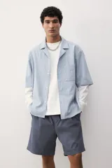 Short gris de lona de algodón, con cintura elástica ajustable con cordón, bolsillos laterales y bolsillo trasero.