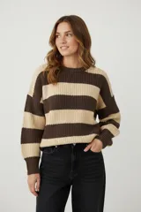 Sweater de tejido grueso, con cuello redondo y diseño de rayas horizontales anchas en tonos marrón oscuro y beige claro. Presenta un calce holgado y mangas largas con puños acanalados.