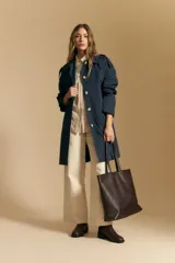 Camisa de manga larga color beige claro con bordado de flores blancas en relieve, cuello clásico y corte holgado.