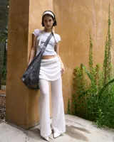 Pantalón blanco de gasa con cintura elastizada y cierre lateral. Incluye pollera superpuesta.