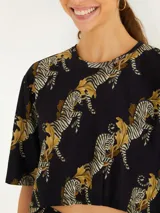 Remera corta negra con estampado de cebras en tonos dorados.