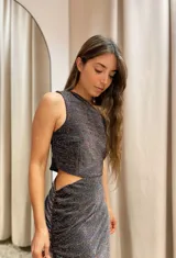 Vestido largo color dorado de lurex, con un hombro descubierto, corte en la cintura y falda con frunces y abertura lateral.