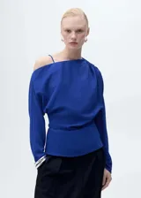 Blusa azul eléctrico con detalle fruncido en el hombro, tirante fino, diseño recto, cuello asimétrico, cierre de cremallera lateral y manga larga.