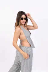 Top chaleco azul con rayas verticales blancas, escote halter y espalda descubierta.