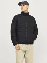 Campera puffer negra de poliéster, con cuello alto, cierre frontal con cremallera, bolsillos laterales y puños elásticos.