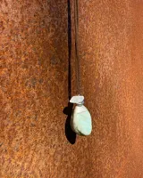 Collar con cordón de cuero marrón y dije de piedra turquesa y cristal.