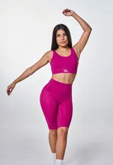 Conjunto deportivo fucsia compuesto por top con logo y calza ciclista de tiro alto.