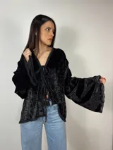 Blusa negra de terciopelo con escote en V y mangas anchas. Se ata al frente con lazos.