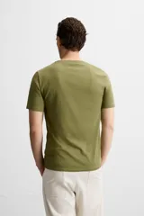 Camiseta slim fit de cuello redondo y manga corta, confeccionada en tejido de algodón con elasticidad.