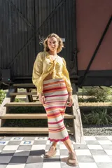 Pollera midi tejida a rayas horizontales en tonos beige, naranja, fucsia y gris.