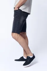 Bermuda de jean color gris oscuro con efecto lavado, corte a la rodilla y terminación desflecada.