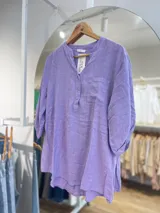 Blusa celeste de algodón con cuello mao, mangas 3/4 con puños elásticos, cierre parcial con botones y bolsillo de parche en el pecho.