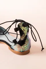 Bailarinas con puntera y talonera a contraste con lentejuelas negras y animal print iridiscente. Cordón negro con borla en animal print iridiscente.