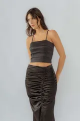 Top corto negro con tirantes finos y diseño a capas horizontales.