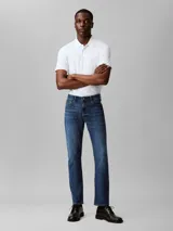 Pantalón de jean azul oscuro, corte slim, con bolsillos delanteros y traseros, cierre con cremallera y botón.