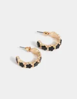 Aros tipo argolla dorados con flores esmaltadas negras.