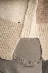 Sweater de tejido de punto con diseño color block. Cuerpo principal en beige jaspeado, mangas y puños en azul marino, y detalles en marrón en el cuello y puños.