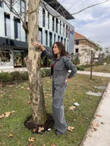 Chaqueta de jean gris con cuello clásico, cierre frontal con botones, dos bolsillos con solapa en el pecho y estampado de rosas con strass en el frente y la espalda.