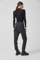 Jeans boyfriend negro con lavado stone wash, tiro alto, rotura en la rodilla y bota desflecada.