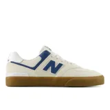 Championes New Balance Numeric 574 color crema con detalles en azul y suela marrón.