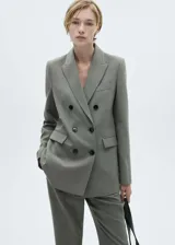 Pantalón de vestir gris con corte flare, tiro medio, bolsillos laterales y traseros.
