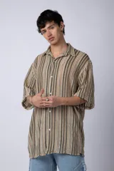 Camisa de manga corta con cuello solapa, corte holgado y estampado de rayas verticales en tonos beige, negro y rojo.