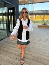 Chaleco de cuero marrón con detalle de tachas en el contorno.