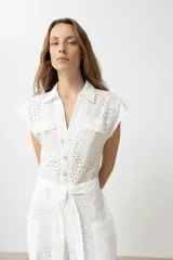 Mono largo blanco con broderie, corte palazzo, cuello camisero, mangas cortas y cinturón de lazo.