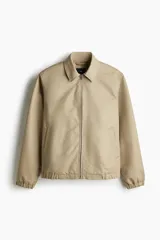 Campera color beige de denim rígido con cuello clásico, cierre frontal, bolsillos insertados al bies y un bolsillo interior. Elástico revestido en puños y bajo. Corte estándar y forrada.