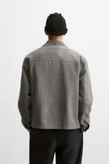 Sobrecamisa gris de corte regular, con cuello solapa, manga larga con puño abotonado y cierre frontal con botones.
