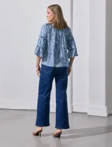 Blusa celeste con estampado floral blanco, escote con frunces y mangas 3/4 con volados.