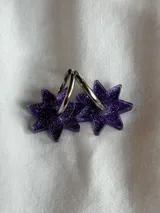 Par de aros dorados con forma de estrella negra.