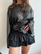 Mini falda negra con volantes y cintura elástica, ideal para looks de verano.