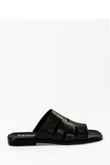 Sandalia de cuero negro con tiras anchas y diseño minimalista.