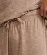 Conjunto de pijama corto para hombre, compuesto por una remera de manga corta con cuello redondo y un short con cintura elástica y cordón de ajuste. El tejido es malla flameada con efecto mezcla en tono verde claro.