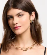 Conjunto de bijouterie dorado con collar de cadena gruesa con eslabones de clips y aros tipo botón con piedra negra.