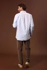 Camisa blanca de manga larga con cuello abotonado.