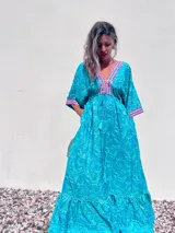 Vestido largo tipo túnica color turquesa con estampado de cachemir y detalles bordados en el escote y las mangas.
