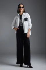 Pantalón negro de talle alto con diseño de pinzas y corte amplio.