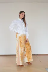 Pantalón de algodón color crudo con estampado de óxidos naturales en tonos marrones, de silueta amplia, tiro alto y diseño especial en los laterales.