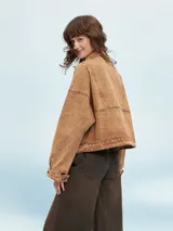 Campera color marrón claro con cuello solapa, cierre frontal con botones y bolsillos con solapa en el pecho.