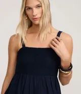 Vestido midi de corte evasé en color azul marino, confeccionado en una mezcla de algodón y lino. Presenta un escote cuadrado con tirantes anchos y un detalle de tejido con efecto crochet en la zona del busto.