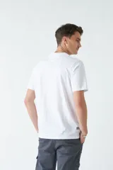 Remera marrón de algodón con cuello redondo, corte regular y estampado en el pecho. El modelo usa talle M.