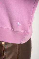 Sweater lila de algodón, corte holgado, con cuello redondo y mangas largas.