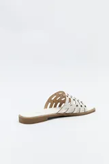 Sandalia baja negra con diseño entrelazado y apliques metálicos.